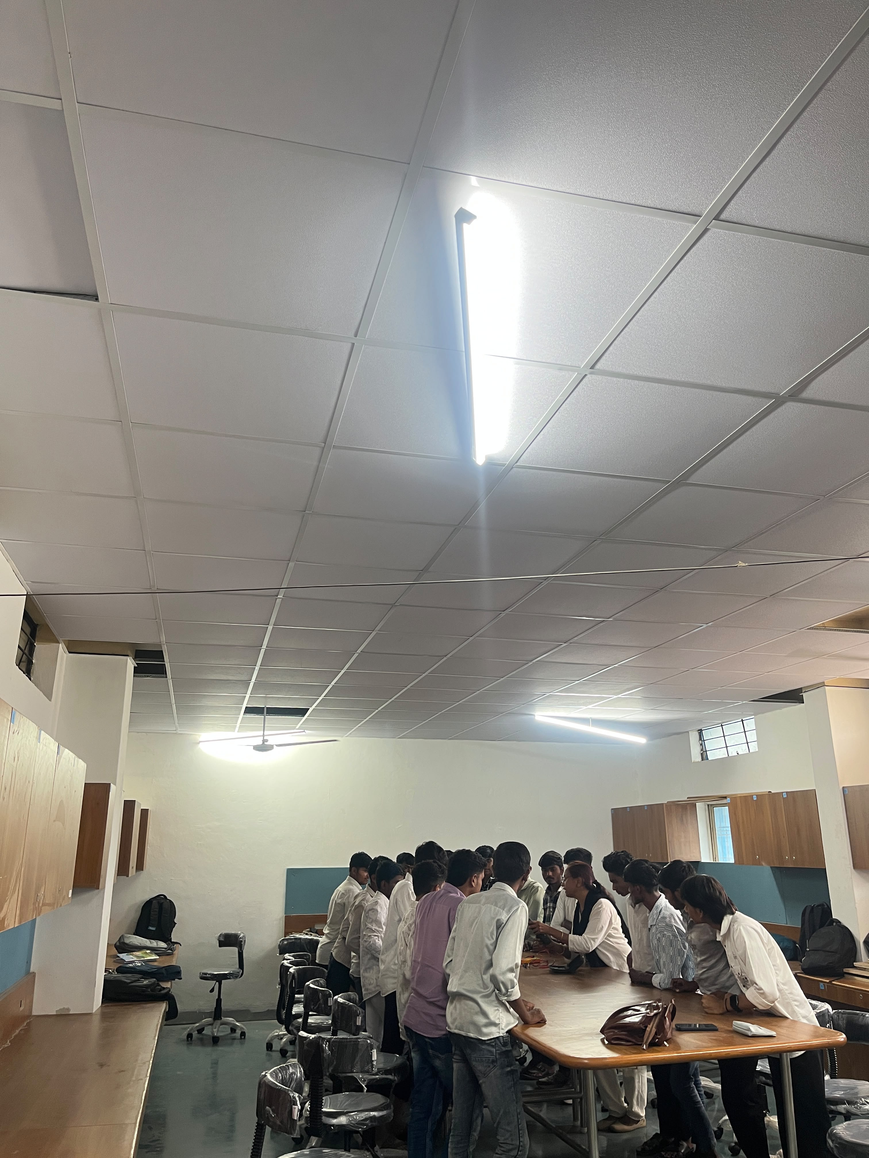Instructor explaining an oscilloscope to electronics mechanic trainees